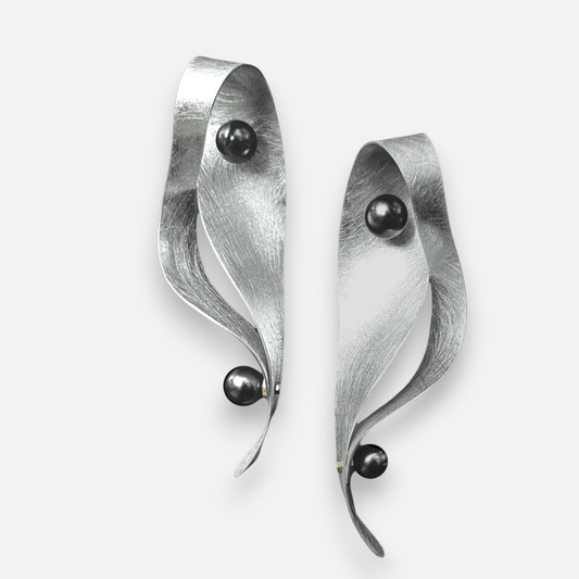 Chick Boss VIBE 2 long wavy aluminum dangle earrings featuring textured silver surfaces and black simulated pearls.
